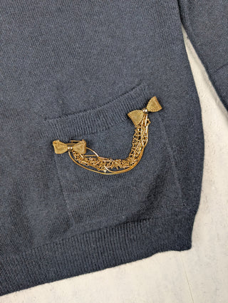 Navy V-Neck Cashmere Sweater Ffeatures A Golden Brooch With Bow Charms On A Lower Left Pocket