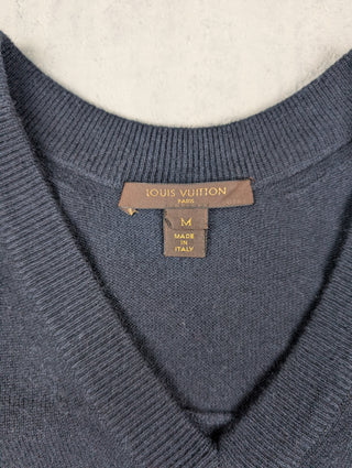 Navy V-Neck Cashmere Sweater Ffeatures A Golden Brooch With Bow Charms On A Lower Left Pocket